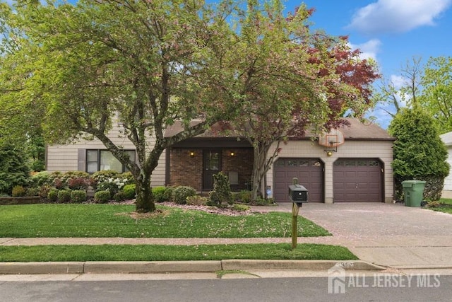view of property hidden behind natural elements featuring a front yard, concrete driveway, and a garage