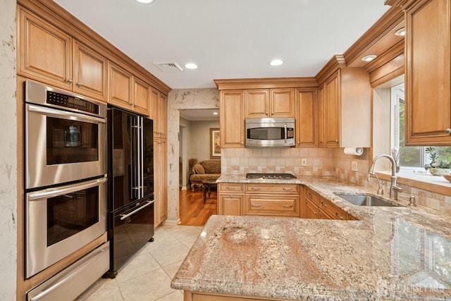 kitchen featuring light stone countertops, light tile patterned floors, visible vents, a sink, and appliances with stainless steel finishes