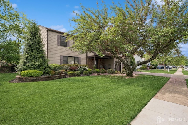 view of property hidden behind natural elements featuring a front yard