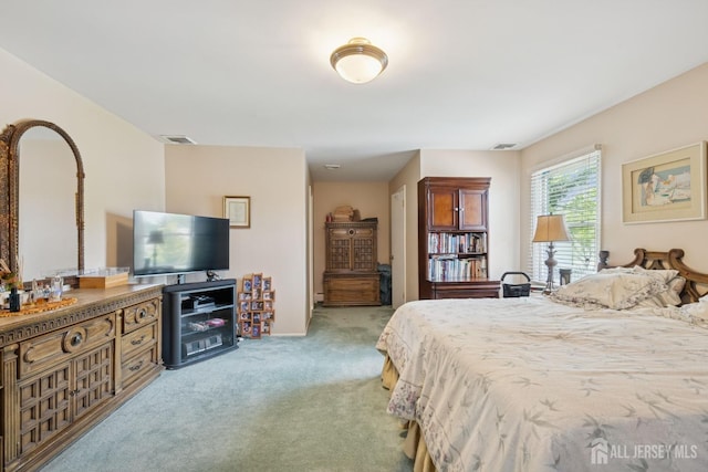 bedroom featuring visible vents and light colored carpet
