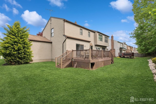 back of property featuring a lawn, a deck, and a chimney