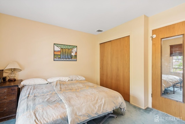bedroom with carpet, visible vents, baseboards, and a closet