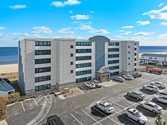 view of building exterior featuring a water view and uncovered parking