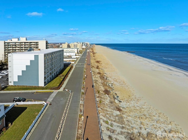 drone / aerial view featuring a city view, a beach view, and a water view