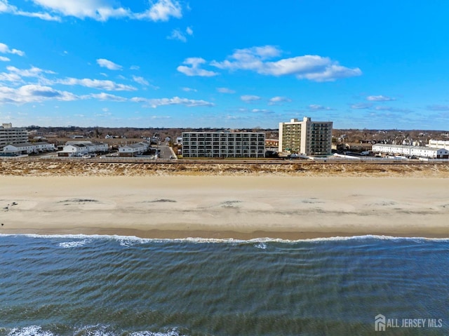 birds eye view of property featuring a view of city, a view of the beach, and a water view