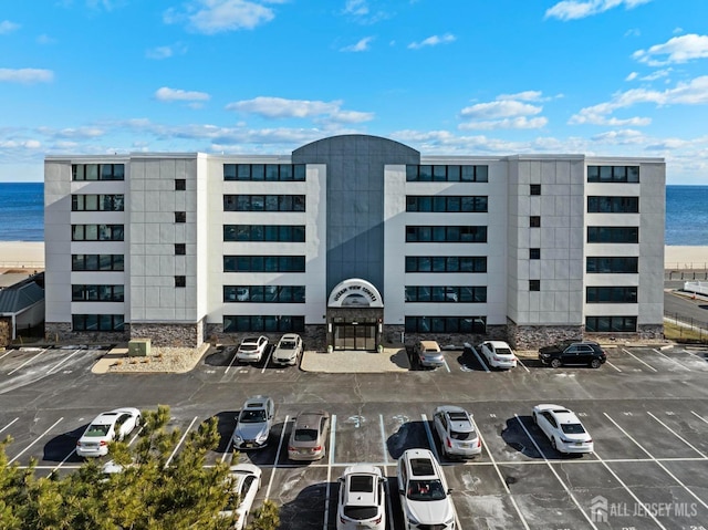 view of property with a water view and uncovered parking