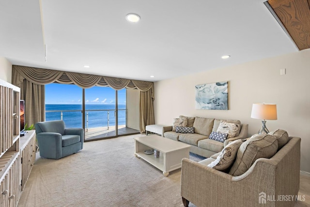 living room with recessed lighting, light colored carpet, and a water view