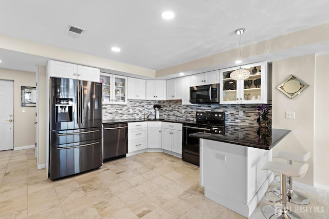 kitchen with a peninsula, glass insert cabinets, visible vents, and appliances with stainless steel finishes