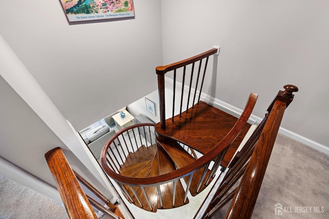 stairway featuring baseboards and carpet floors