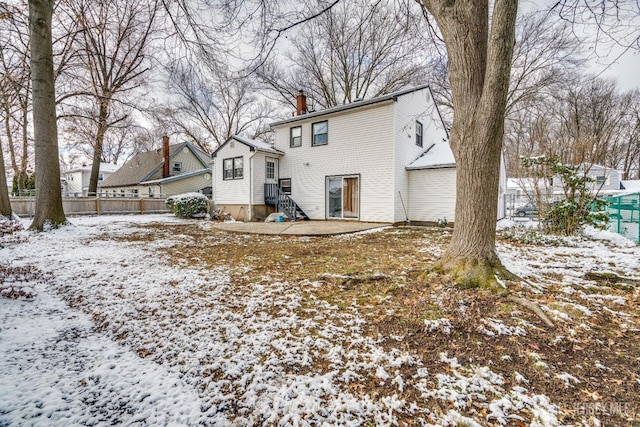 view of snow covered back of property