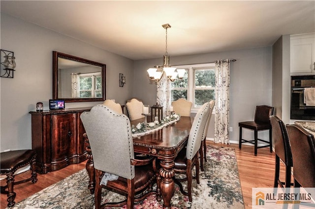 dining room with a chandelier and light wood-type flooring