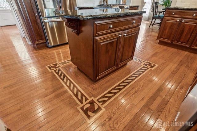 11 Cardinal Ct, Old Bridge, NJ 08857 - kitchen with light wood finished floors, a kitchen island, dark stone countertops, and fridge