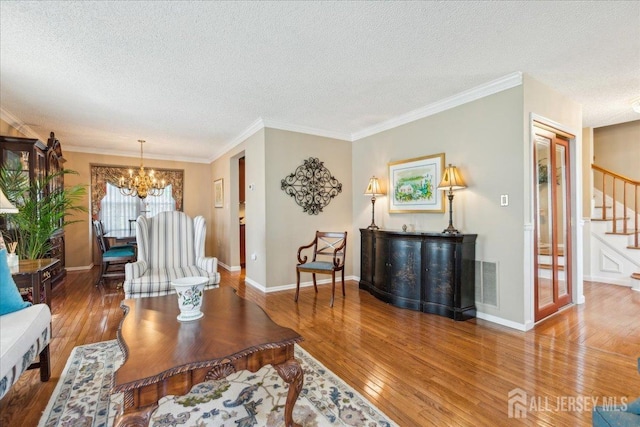 11 Cardinal Ct, Old Bridge, NJ 08857 - living area featuring stairs, wood-type flooring, a textured ceiling, a chandelier, and ornamental molding