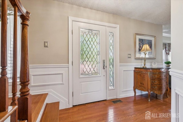 11 Cardinal Ct, Old Bridge, NJ 08857 - entrance foyer featuring a decorative wall, wood finished floors, a wainscoted wall, and a textured ceiling