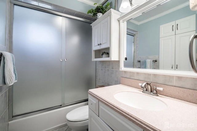 108 Colonia Rd, Colonia, NJ 07067 - bathroom featuring toilet, tile walls, crown molding, combined bath / shower with glass door, and vanity