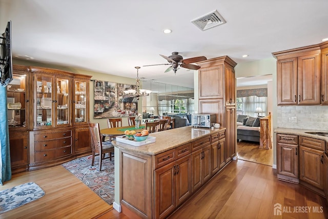 108 Colonia Rd, Colonia, NJ 07067 - kitchen with light wood finished floors, visible vents, light stone countertops, pendant lighting, and ceiling fan with notable chandelier