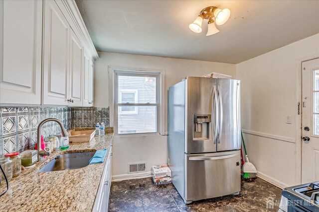 803 W Inman Ave W, Rahway, NJ 07065 - kitchen with baseboards, visible vents, a sink, stainless steel refrigerator with ice dispenser, and white cabinets