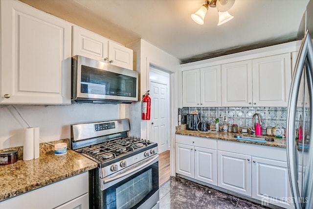 803 W Inman Ave W, Rahway, NJ 07065 - kitchen with a sink, white cabinets, backsplash, appliances with stainless steel finishes, and light stone counters