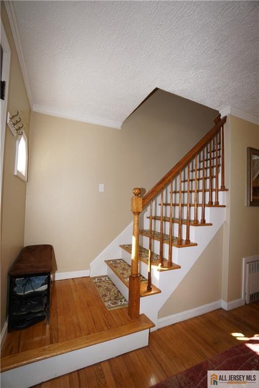 25 Clover Ave, Colonia, NJ 07067 - stairs featuring radiator heating unit, wood finished floors, ornamental molding, baseboards, and a textured ceiling