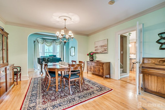44 Rector St, Metuchen, NJ 08840 - dining area with arched walkways, a chandelier, light wood-style flooring, and ornamental molding
