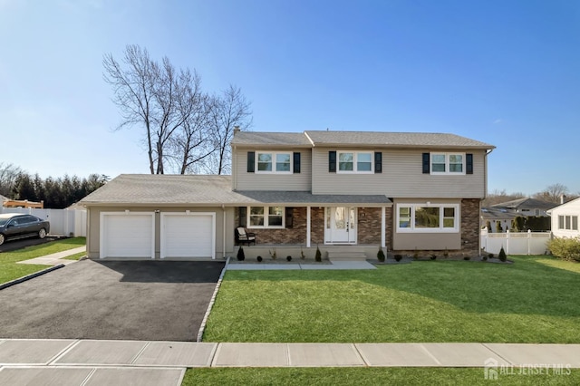 view of front of property with aphalt driveway, an attached garage, brick siding, fence, and a front lawn