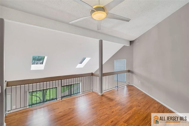 22 Witch Hazel Ct, South Brunswick, NJ 08852 - spare room featuring a skylight, wood finished floors, lofted ceiling, ceiling fan, and a textured ceiling