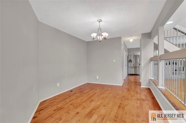 22 Witch Hazel Ct, South Brunswick, NJ 08852 - empty room with a chandelier, wood finished floors, and a textured ceiling