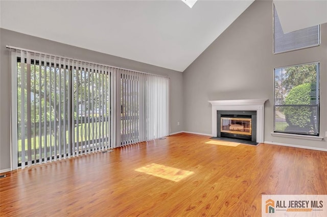 22 Witch Hazel Ct, South Brunswick, NJ 08852 - unfurnished living room featuring high vaulted ceiling, wood finished floors, and a fireplace with flush hearth