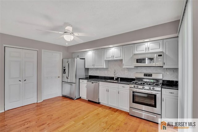 22 Witch Hazel Ct, South Brunswick, NJ 08852 - kitchen featuring appliances with stainless steel finishes, dark countertops, tasteful backsplash, light wood-type flooring, and ceiling fan