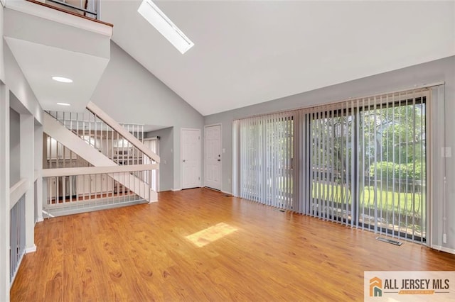 22 Witch Hazel Ct, South Brunswick, NJ 08852 - unfurnished living room with high vaulted ceiling, wood finished floors, a skylight, and stairs