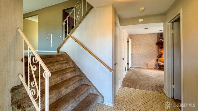 staircase with baseboards, carpet floors, and wallpapered walls