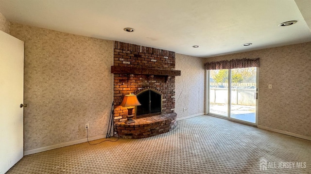 unfurnished living room with a fireplace, baseboards, and carpet flooring