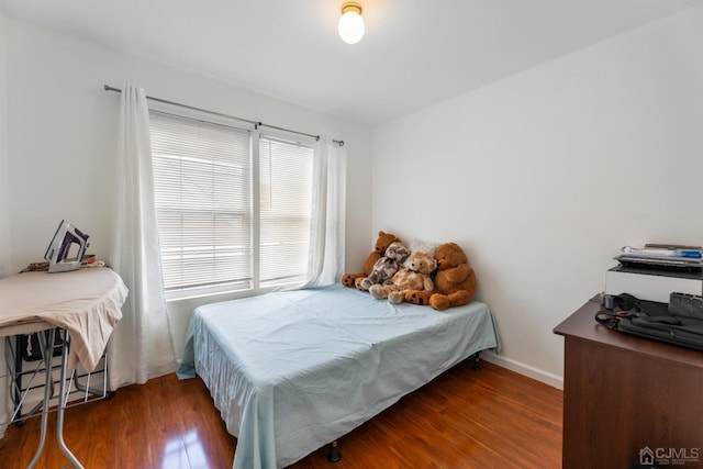 bedroom featuring wood finished floors and baseboards