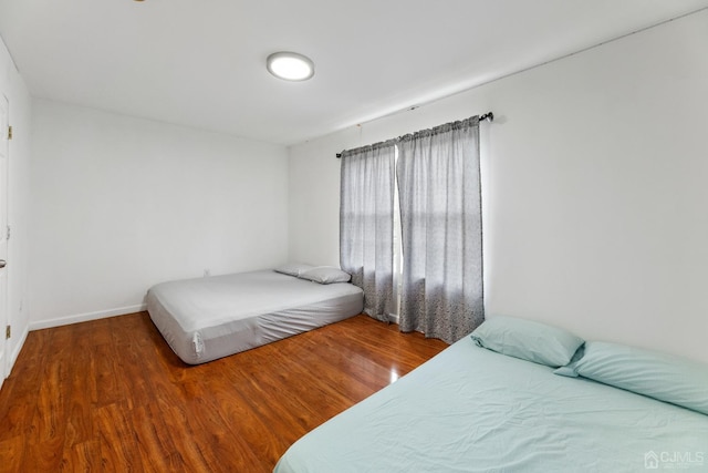 bedroom featuring wood finished floors and baseboards