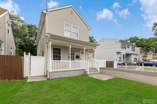 view of front of house featuring covered porch and a front lawn