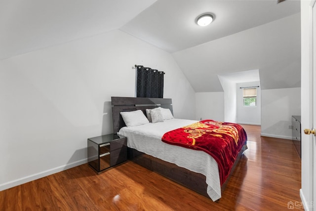 bedroom featuring hardwood / wood-style floors and lofted ceiling