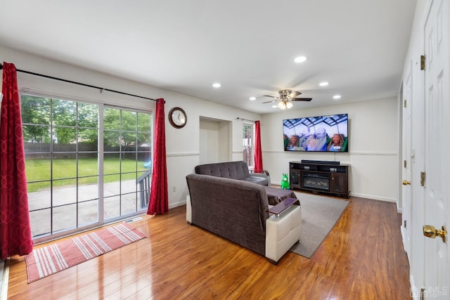 living room featuring visible vents, baseboards, ceiling fan, wood finished floors, and recessed lighting