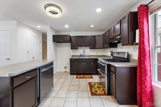 kitchen featuring dark brown cabinetry, sink, light tile patterned floors, and appliances with stainless steel finishes