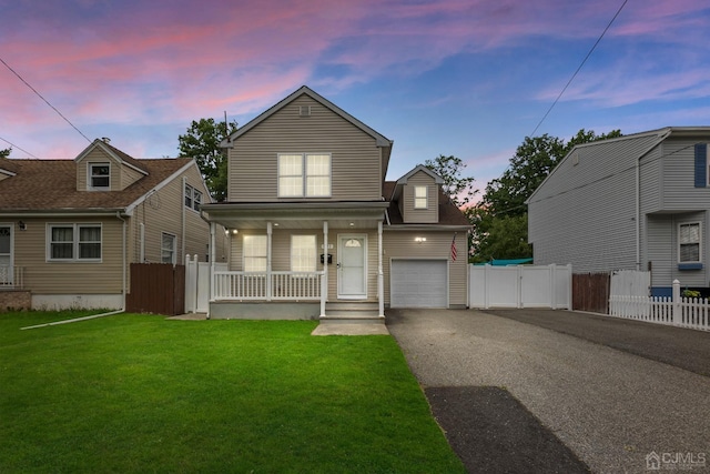 view of front of house featuring a porch, a garage, and a yard