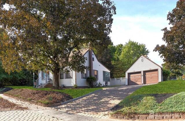 view of front of house with a garage, an outdoor structure, and a front lawn