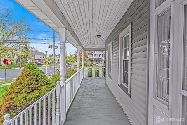 wooden deck with covered porch and a residential view