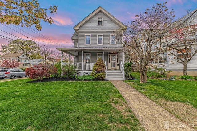 victorian home featuring a porch and a yard