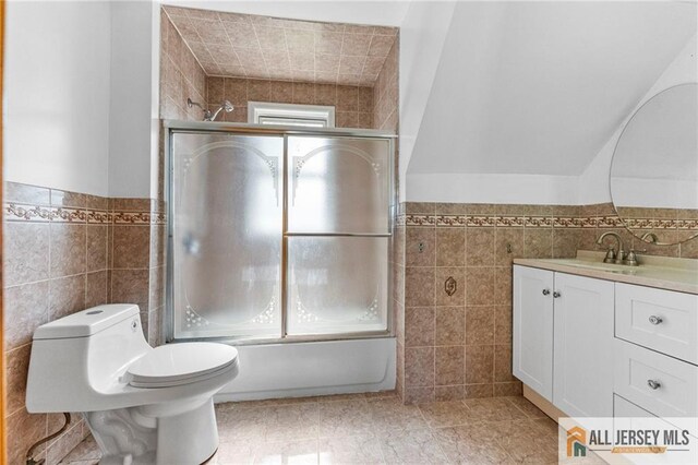 74 Charles St, Carteret, NJ 07008 - bathroom featuring tile walls, vanity, enclosed tub / shower combo, a wainscoted wall, and tile patterned floors
