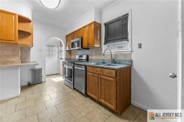 74 Charles St, Carteret, NJ 07008 - kitchen featuring radiator heating unit, stainless steel appliances, arched walkways, a sink, and decorative backsplash