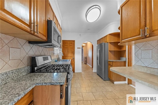 74 Charles St, Carteret, NJ 07008 - kitchen with appliances with stainless steel finishes, a sink, open shelves, arched walkways, and brown cabinetry