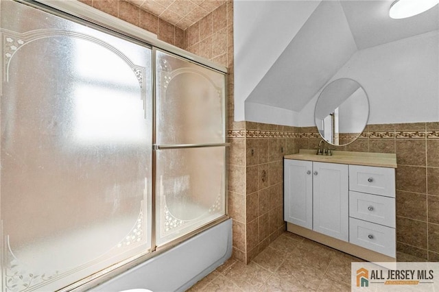 74 Charles St, Carteret, NJ 07008 - bathroom with tile walls, combined bath / shower with glass door, vanity, tile patterned flooring, and wainscoting