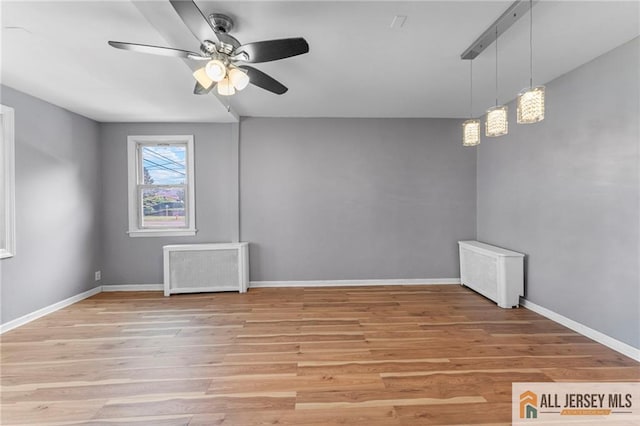 74 Charles St, Carteret, NJ 07008 - empty room featuring ceiling fan, light wood-style floors, radiator heating unit, and baseboards