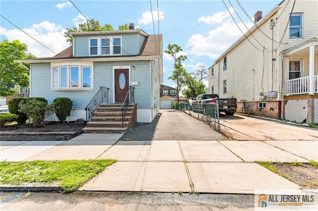 74 Charles St, Carteret, NJ 07008 - view of front of home featuring an outdoor structure, driveway, entry steps, and a chimney
