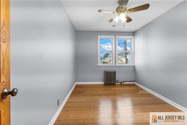 74 Charles St, Carteret, NJ 07008 - unfurnished room featuring radiator heating unit, wood finished floors, baseboards, and a ceiling fan