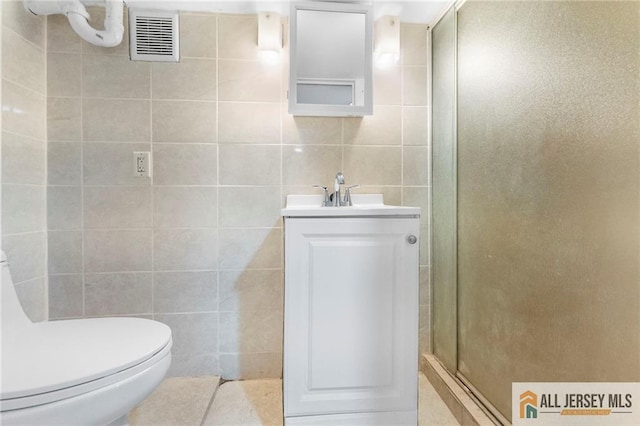 74 Charles St, Carteret, NJ 07008 - full bath with a stall shower, vanity, toilet, and tile walls